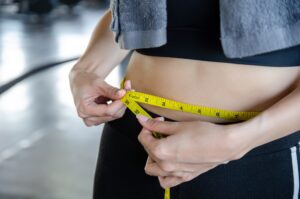 woman check waist size using a tape measure for body